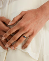 Woman wearing a rose gold engagement ring with three oval sapphire stones.