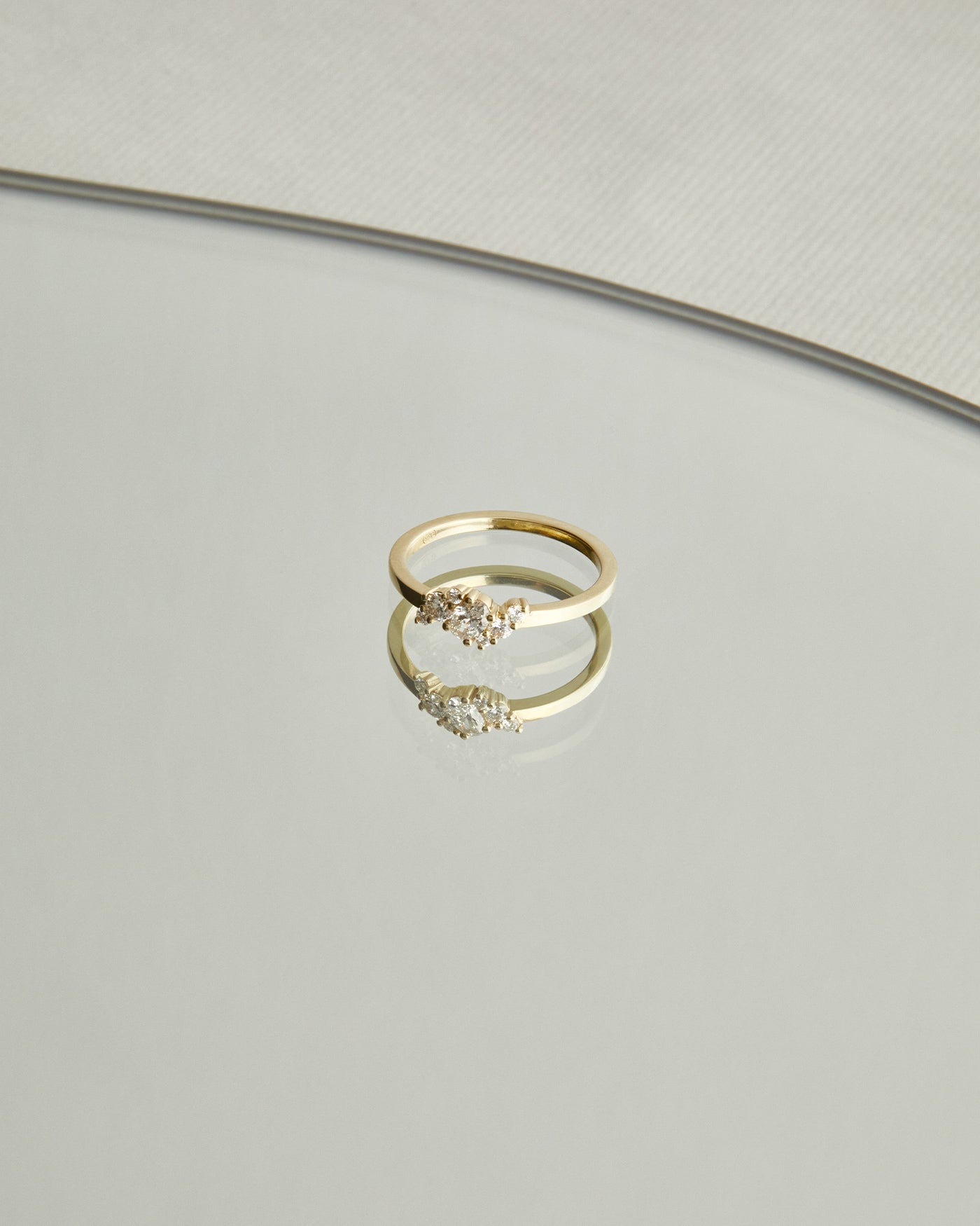 top down image deep  of a yellow gold  engagement ring with a cluster of 7 white diamonds