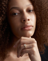 image of woman wearing a yellow gold  engagement ring with a oval  diamond stone