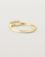 back facing deep etched image of a yellow gold engagement ring with three oval diamonds.