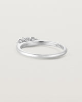 Back facing deep etched image of a white gold engagement ring with three oval white laboratory grown diamonds.