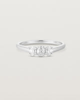 Front on deep etched image of a white gold engagement ring with three oval white laboratory grown diamonds.