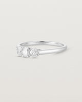 Side facing deep etched image of a white gold engagement ring with three oval white laboratory grown diamonds.