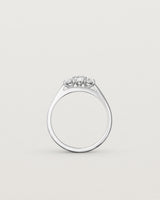 Standing deep etched image of a white gold engagement ring with three oval white laboratory grown diamonds.