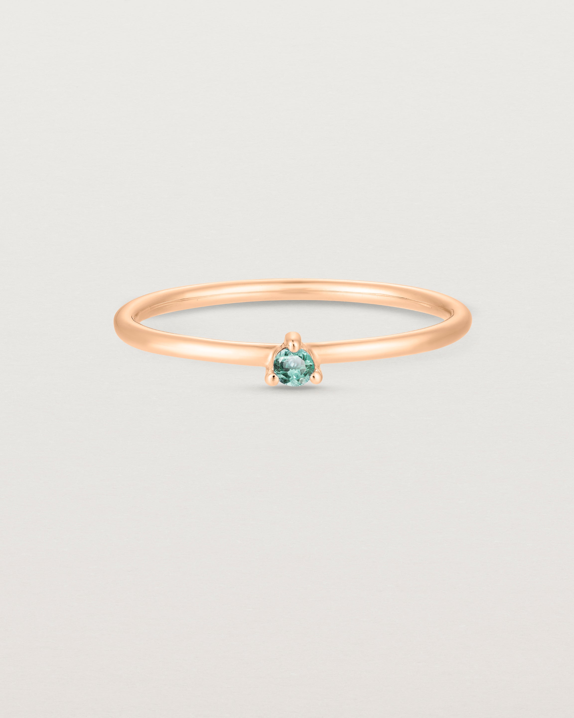 Front facing deep etched image of a rose gold ring with an alexandrite birthstone.