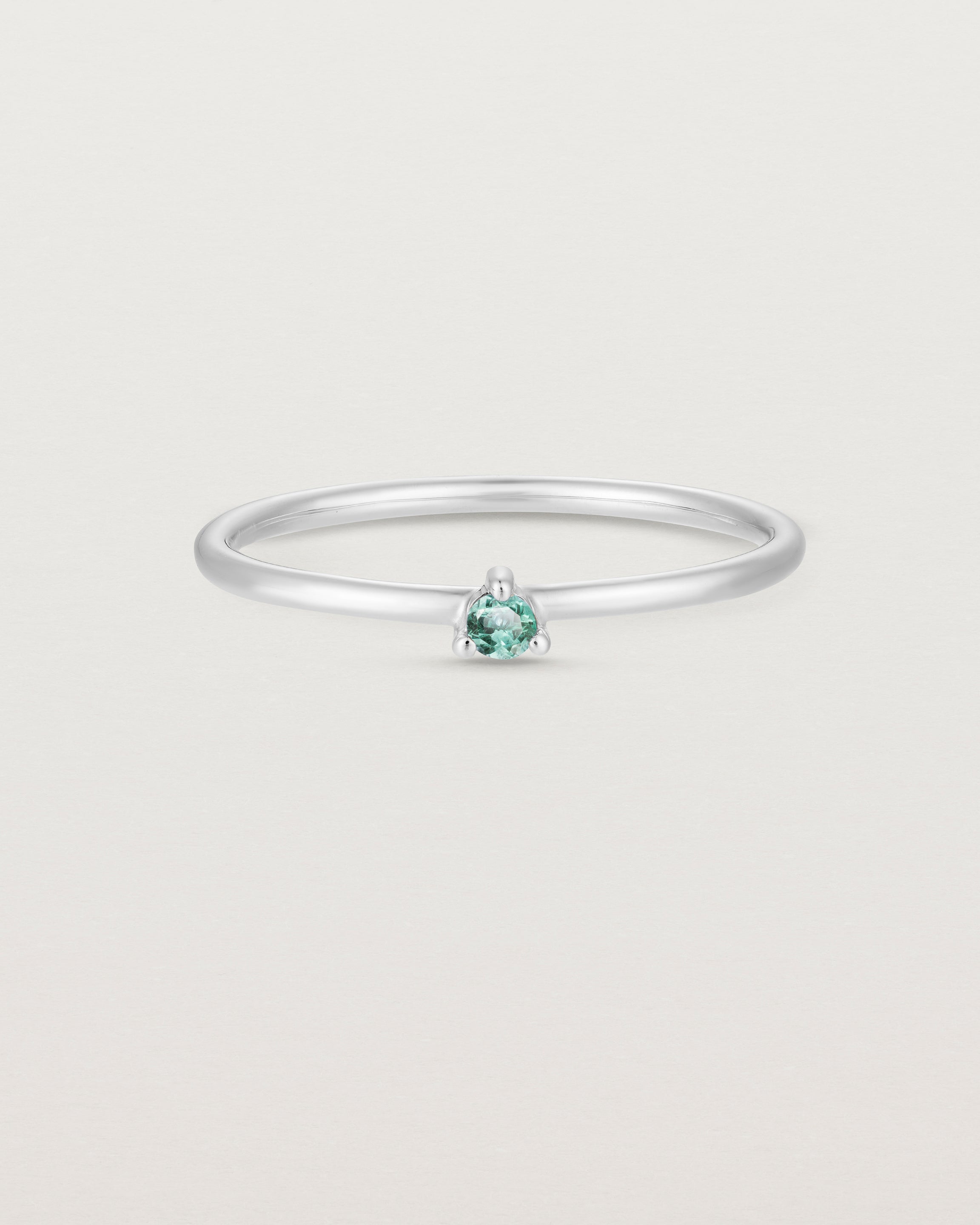 Front facing deep etched image of a white gold ring with an alexandrite birthstone.