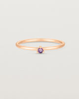 Front facing deep etched image of a rose gold ring with an amethyst birthstone.