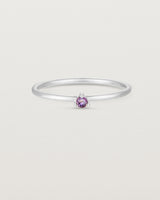 Front facing deep etched image of a white gold ring with an amethyst birthstone.