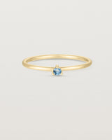 Front facing deep etched image of a yellow gold ring with an aquamarine birthstone.