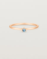 Front facing deep etched image of a rose gold ring with an aquamarine birthstone.