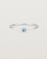 Front facing deep etched image of a white gold ring with an aquamarine birthstone.