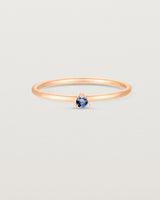 Front facing deep etched image of a rose gold ring with a blue sapphire birthstone.