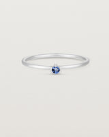 Front facing deep etched image of a white gold ring with a blue sapphire birthstone.