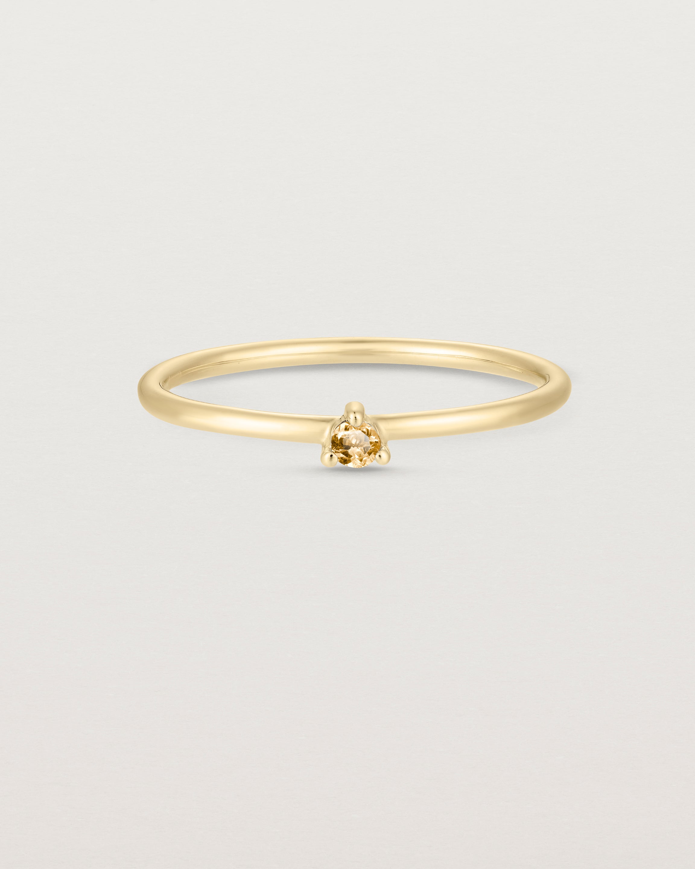 Front facing deep etched image of a yellow gold ring with a citrine birthstone.