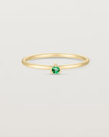 Front facing deep etched image of a yellow gold ring with an emerald birthstone.