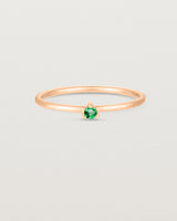 Front facing deep etched image of a rose gold ring with an emerald birthstone.