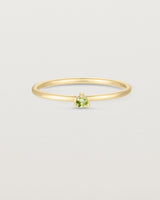 Front facing deep etched image of a yellow gold ring with a peridot birthstone.