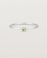 Front facing deep etched image of a white gold ring with a peridot birthstone.