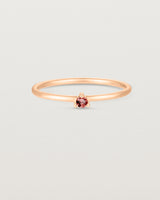 Front facing deep etched image of a rose gold ring with a ruby birthstone.