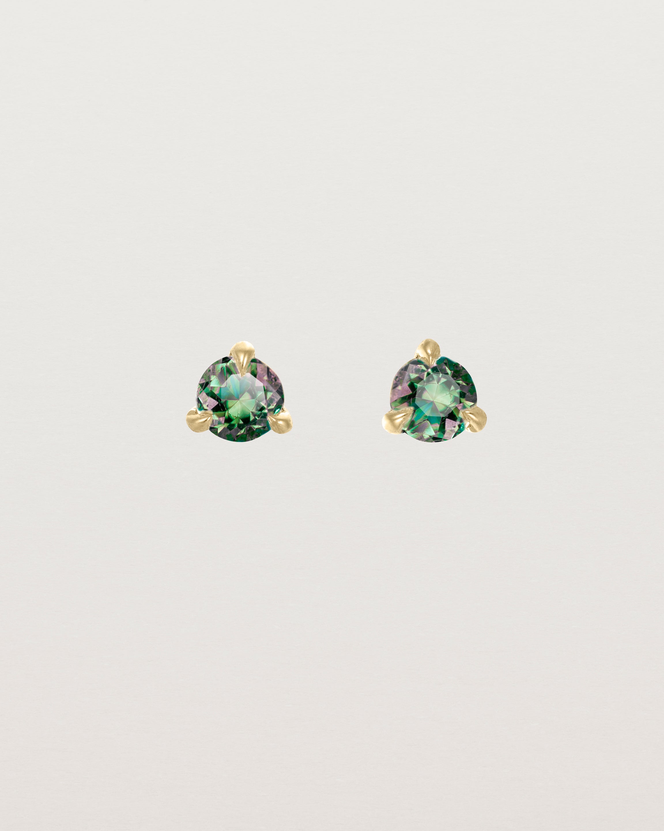 Front facing deep etched image of a pair of yellow gold earrings with an alexandrite birthstone.