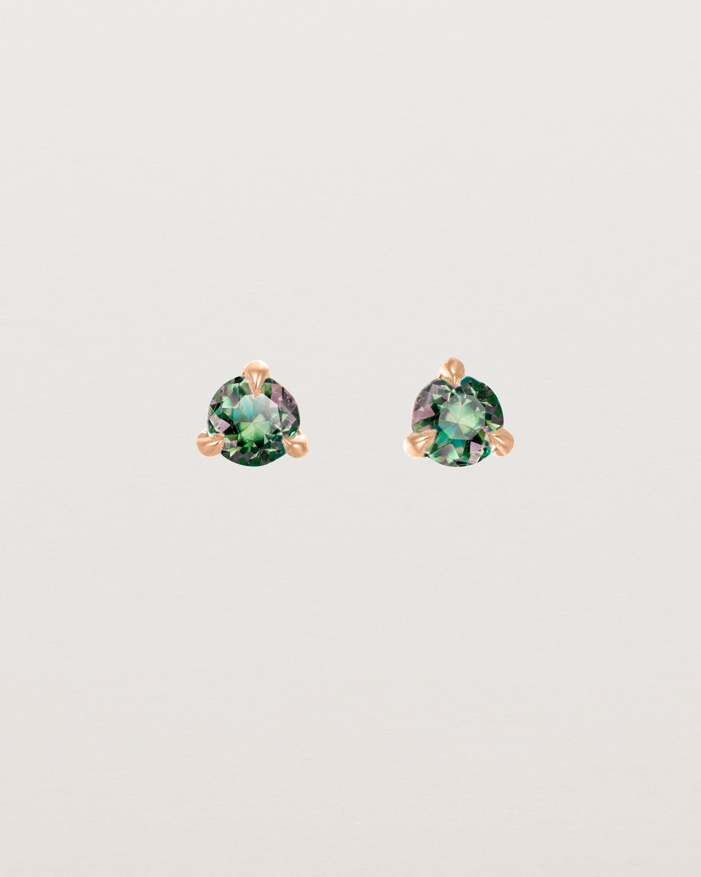 Front facing deep etched image of a pair of rose gold earrings with an alexandrite birthstone.