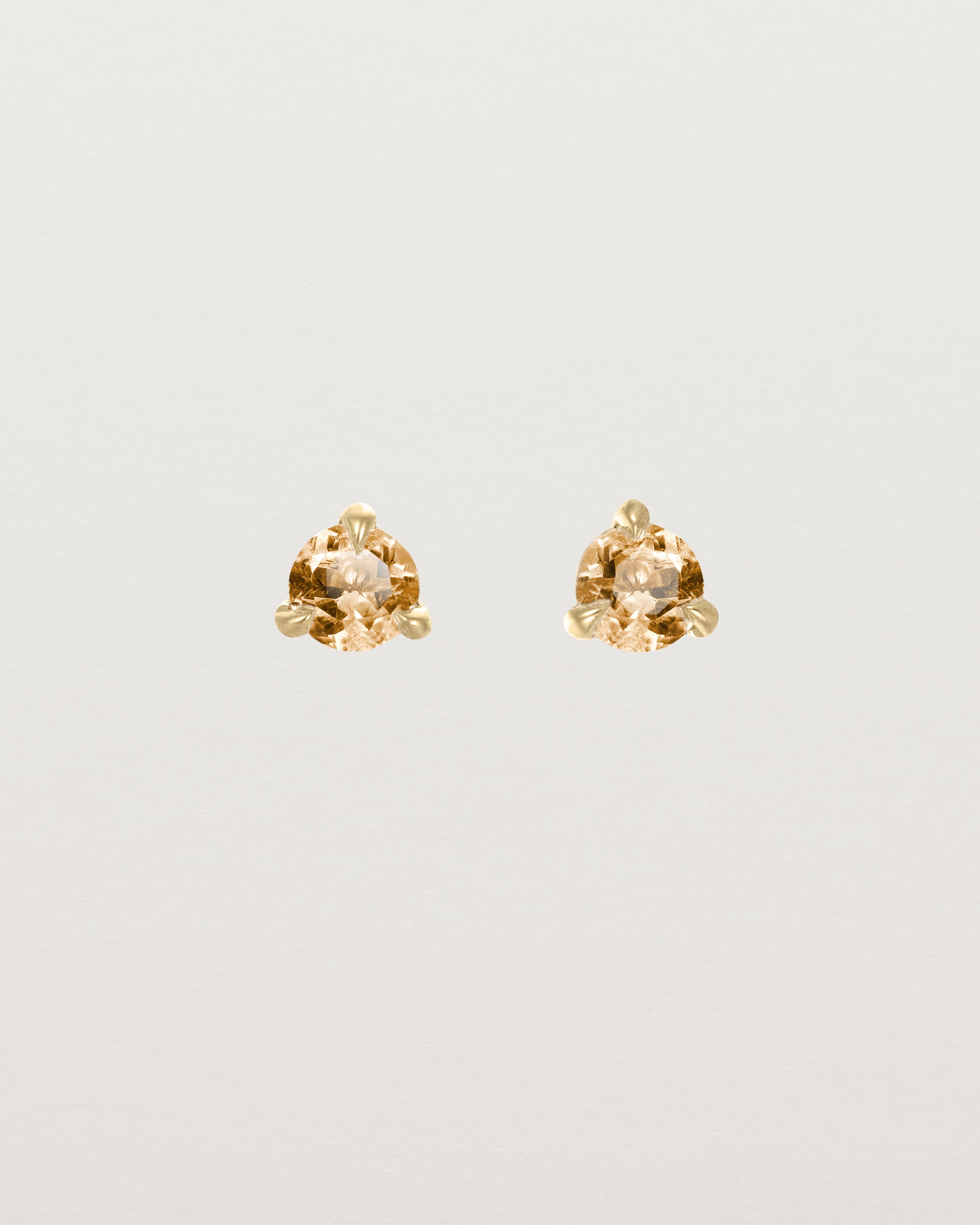 Front facing deep etched image of a pair of yellow gold earrings with a citrine birthstone.