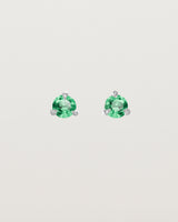 Front facing deep etched image of a pair of white gold earrings with an emerald birthstone.