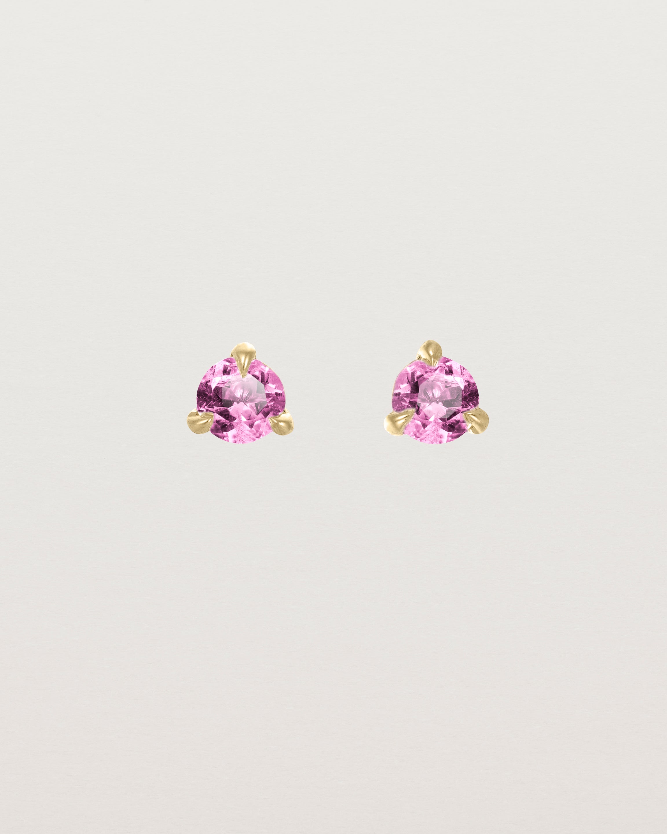 Front facing deep etched image of a pair of yellow gold earrings with a pink tourmaline birthstone.