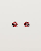 Front facing deep etched image of a pair of white gold earrings with a ruby birthstone.