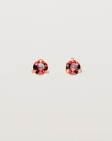 Front facing deep etched image of a pair of rose gold earrings with a garnet birthstone.