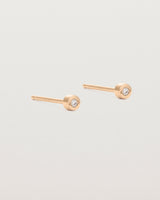 A small white circular rose gold stud featuring a white diamond