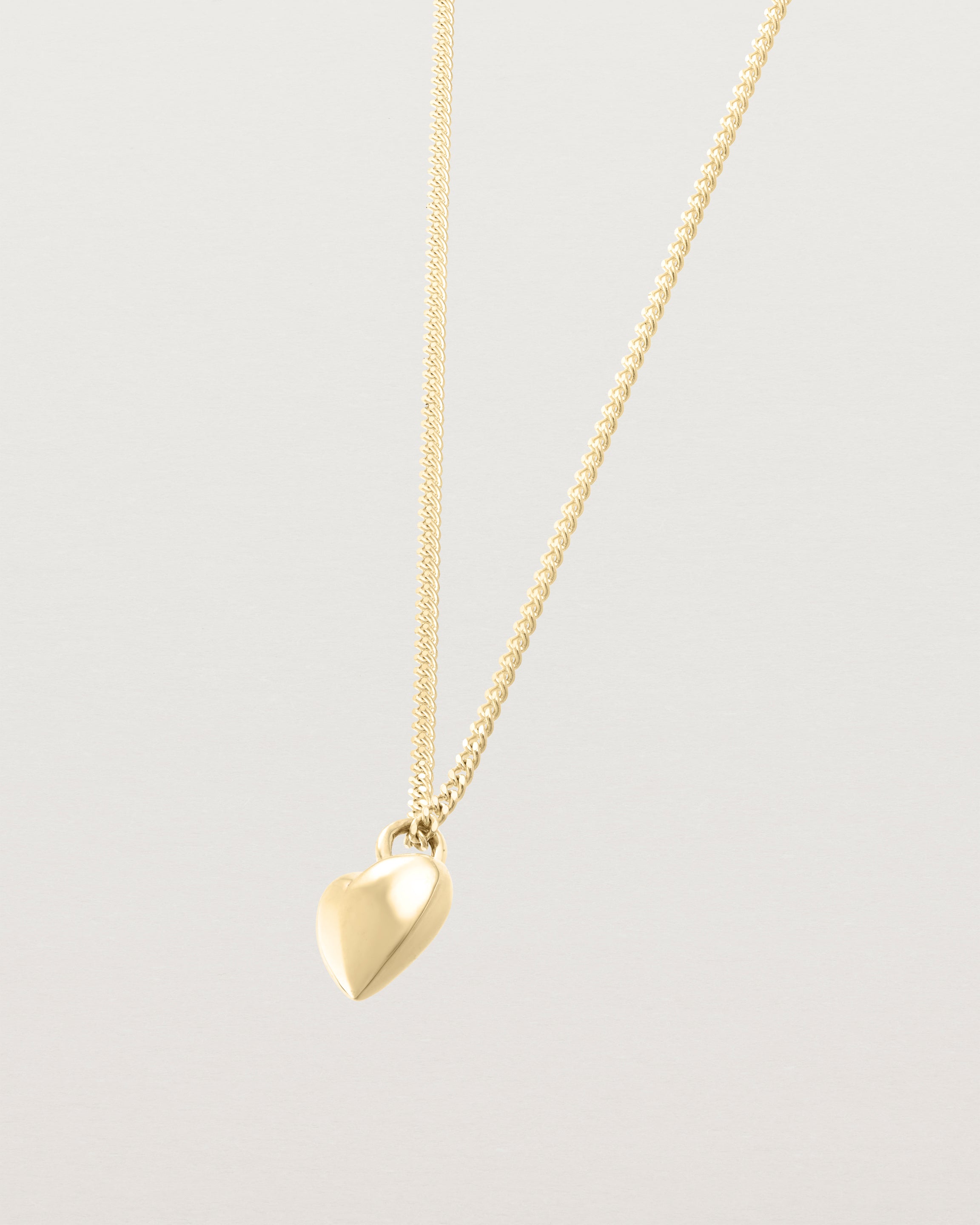 Side image of gold heart necklace.