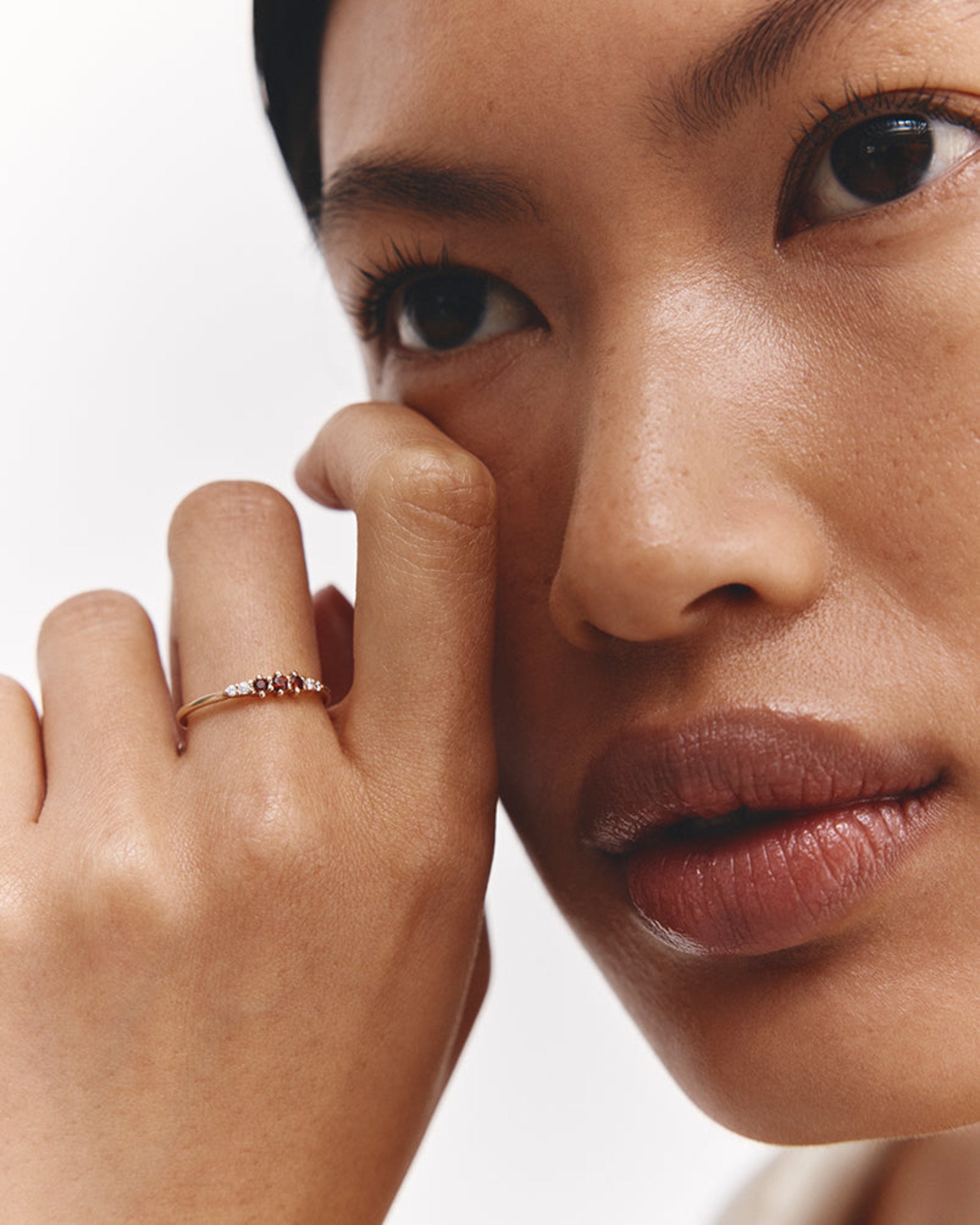 Model wears Hattie stacking ring with Ruby birthstones.