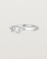 side facing deep etched image of a white gold  engagement ring with a cluster of 7 white diamonds