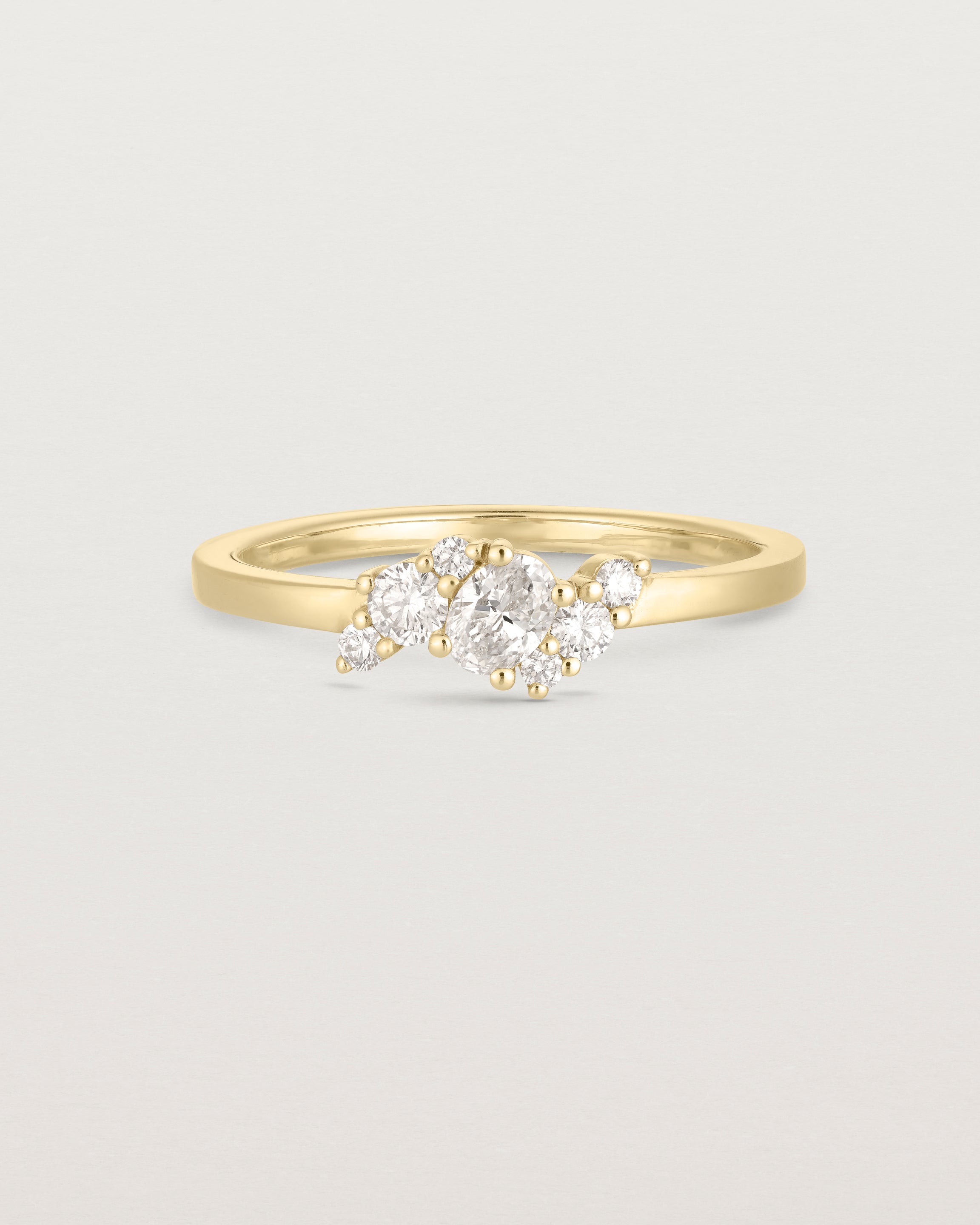 deep etched image of a yellow gold  engagement ring with a cluster of 7 white diamonds