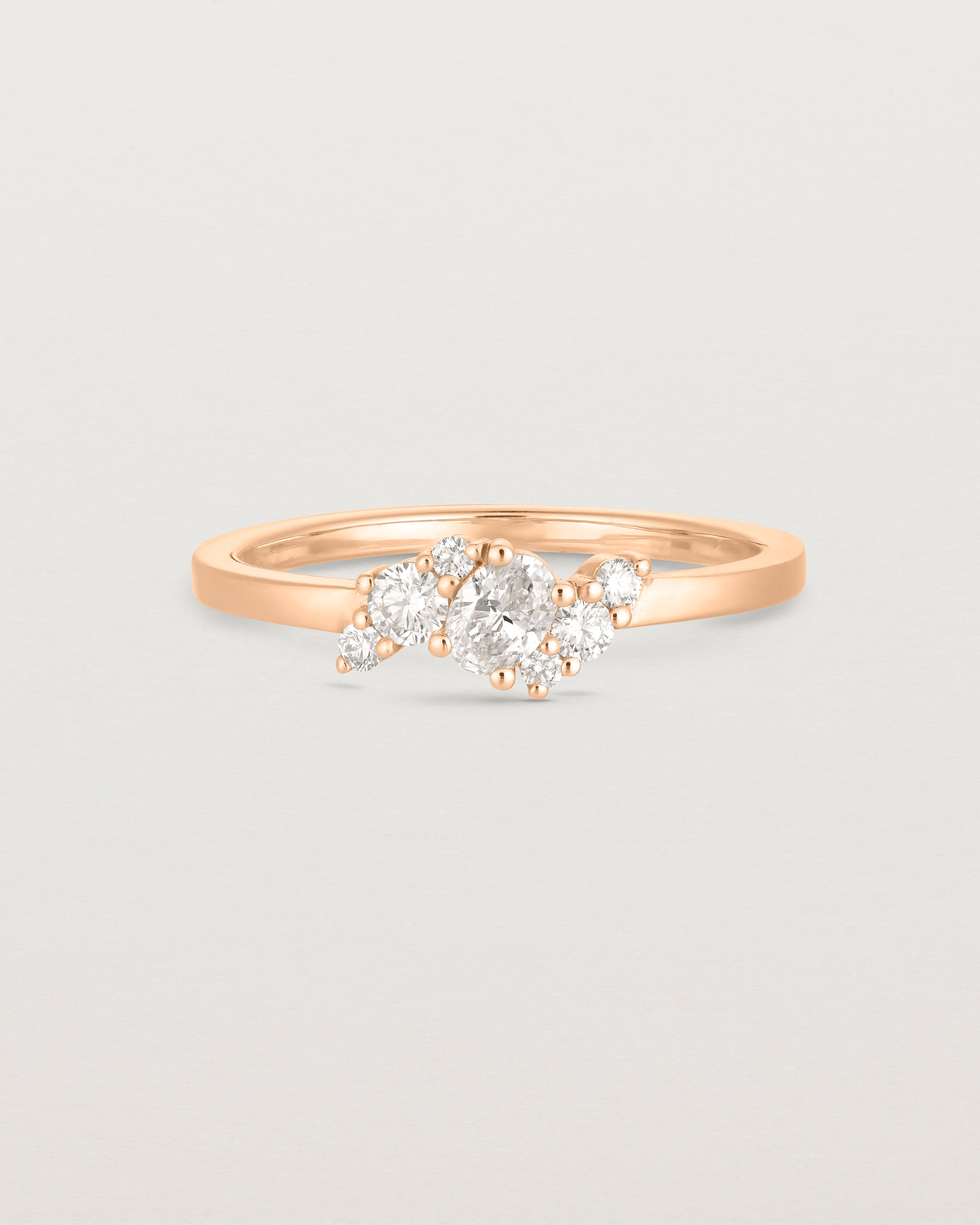 front on deep etched image of a rose gold  engagement ring with a cluster of 7 white diamonds