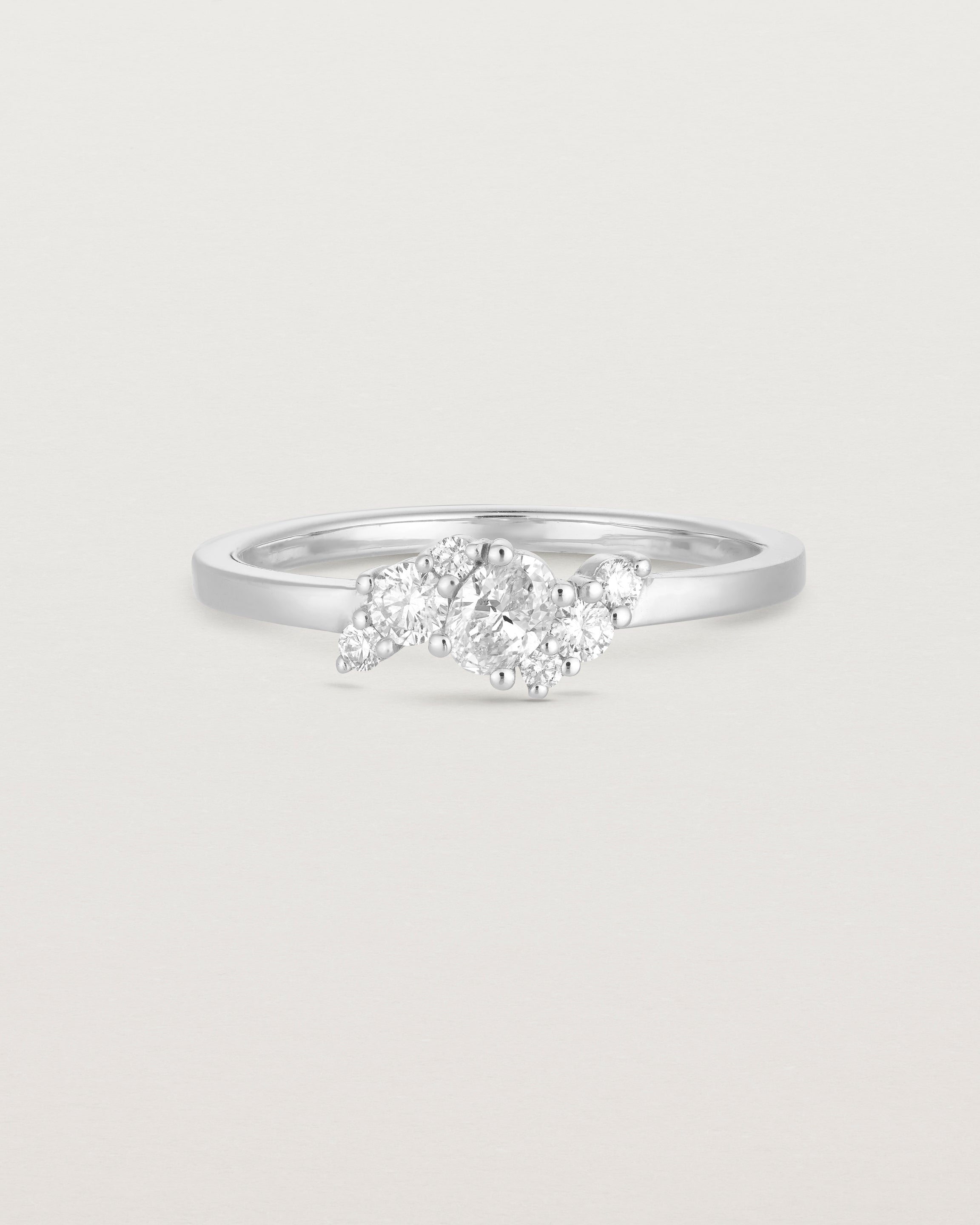 front on deep etched image of a white gold  engagement ring with a cluster of 7 white diamonds