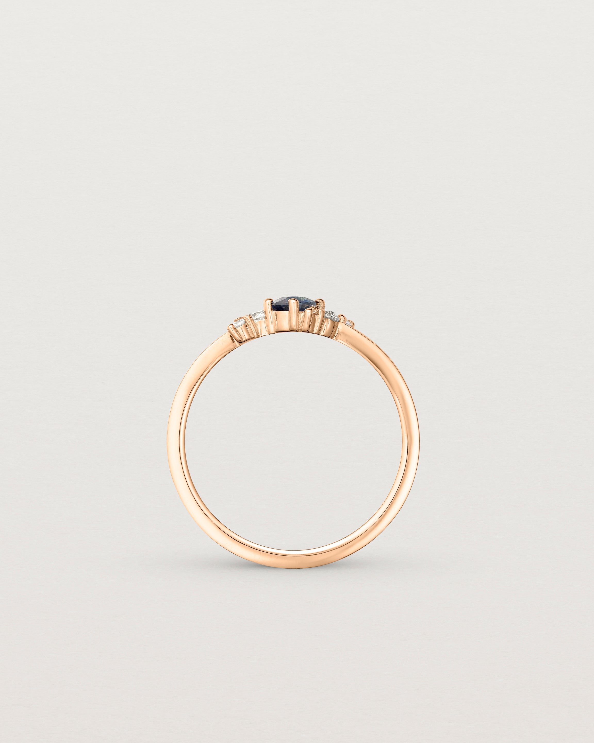 standing etched image of a rose gold  engagement ring with a cluster of d