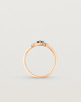 standing etched image of a rose gold  engagement ring with a cluster of d