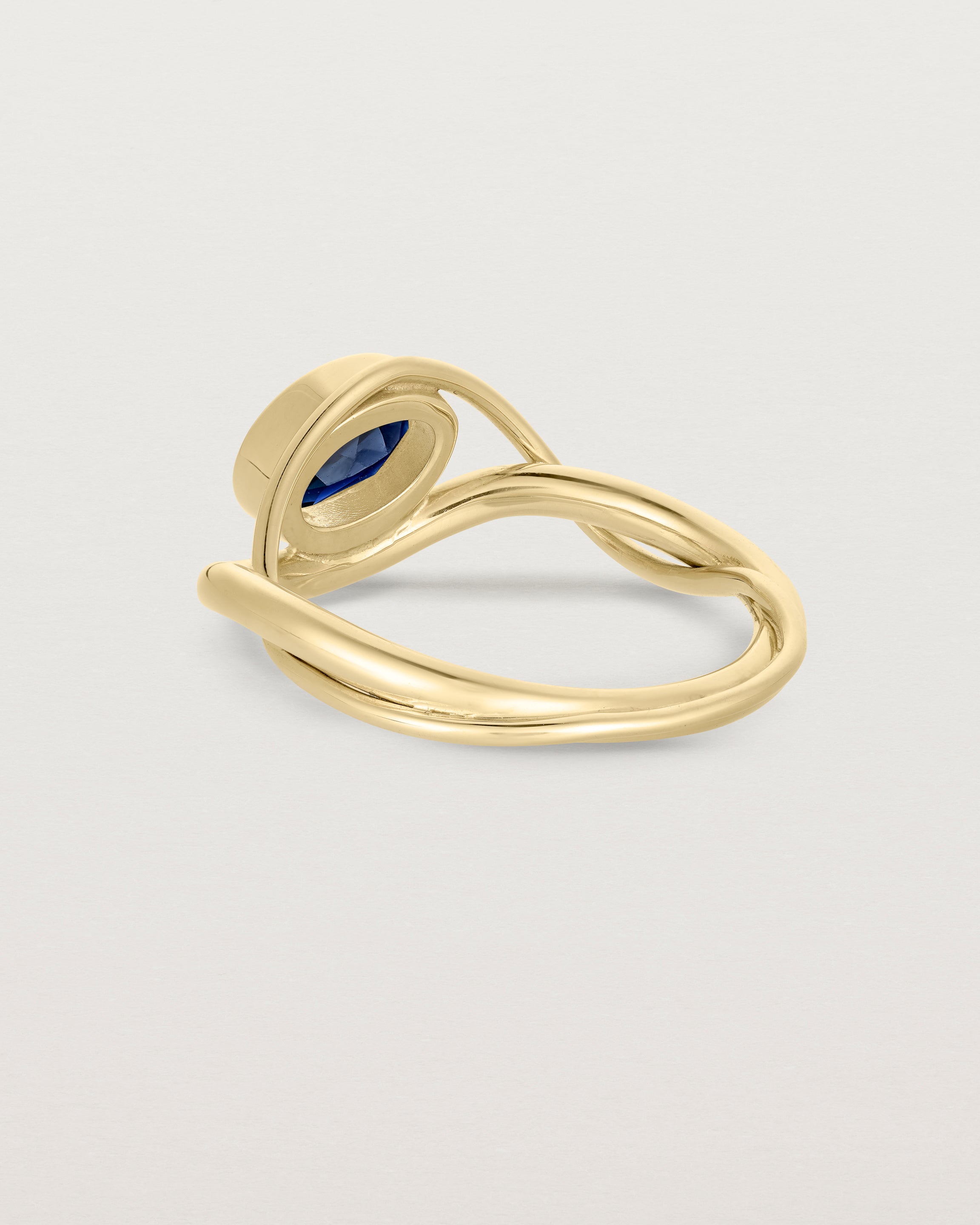 back facing deep etched image of a yellow gold  engagement ring with a oval  sapphire stone