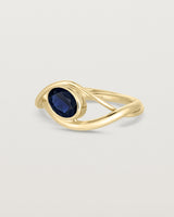 side facing deep etched image of a yellow gold  engagement ring with a oval  sapphire stone