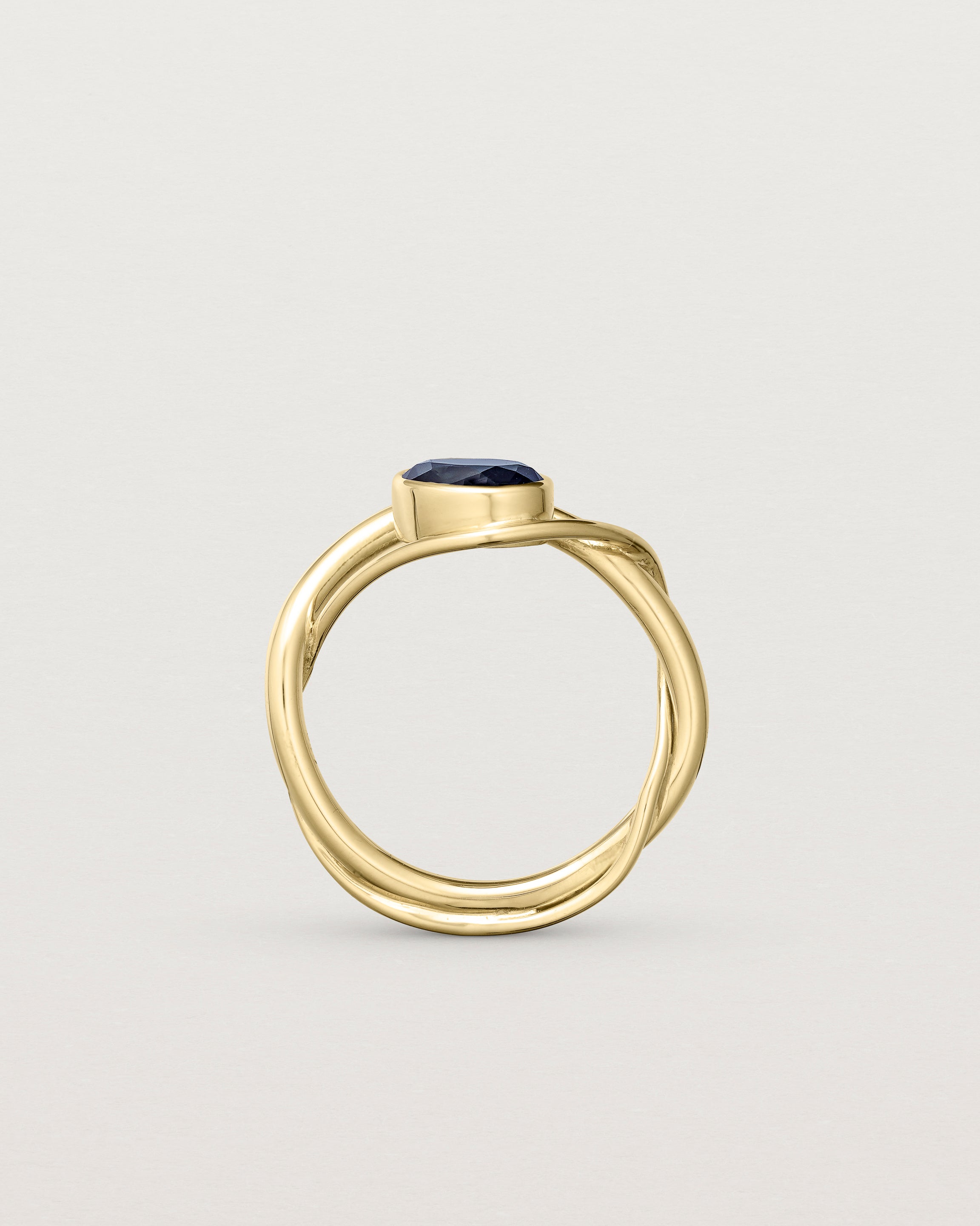 standing deep etched image of a yellow gold  engagement ring with a oval  sapphire stone