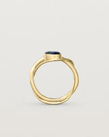 standing deep etched image of a yellow gold  engagement ring with a oval  sapphire stone