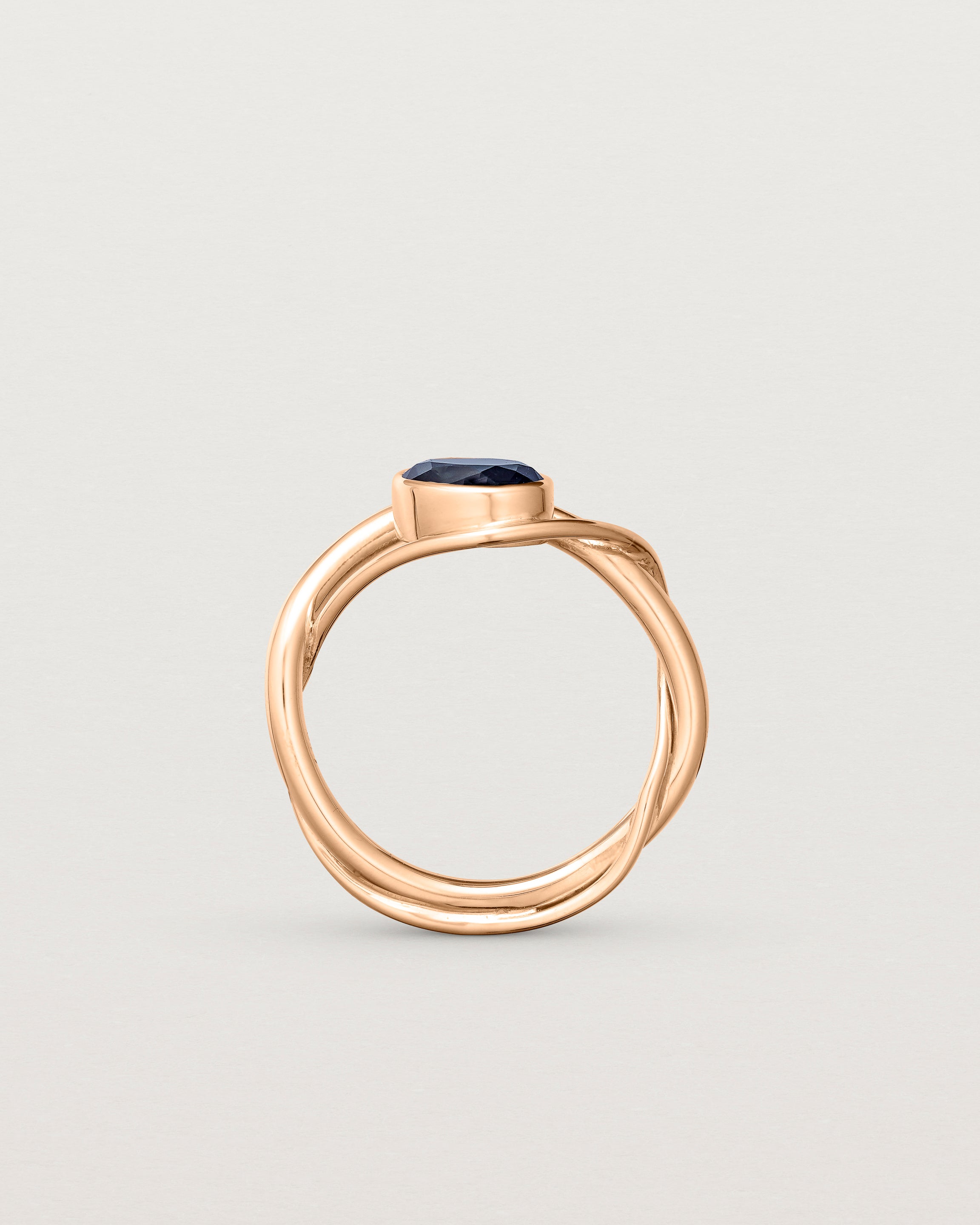 Standing deep etched image of a rose gold  engagement ring with a oval  sapphire stone