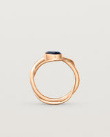 Standing deep etched image of a rose gold  engagement ring with a oval  sapphire stone