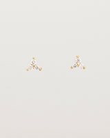 A pair of small yellow gold studs with three small white diamonds.