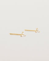 A pair of small yellow gold studs with three small white diamonds.