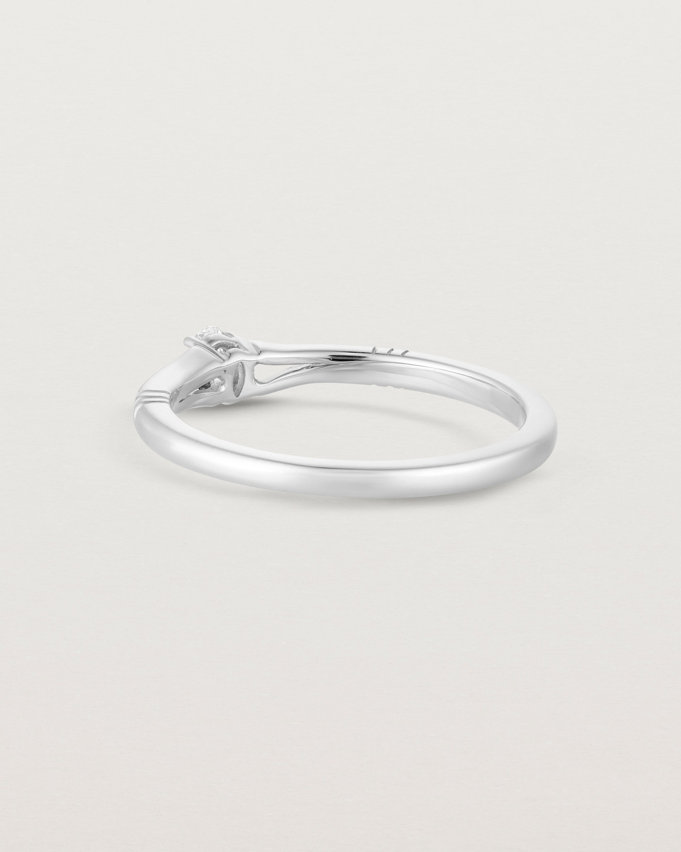 Back facing deep etched image of a white gold engagement ring with an oval diamond.