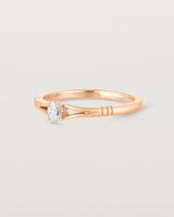 Side on deep etched image of a rose gold engagement ring with an oval diamond