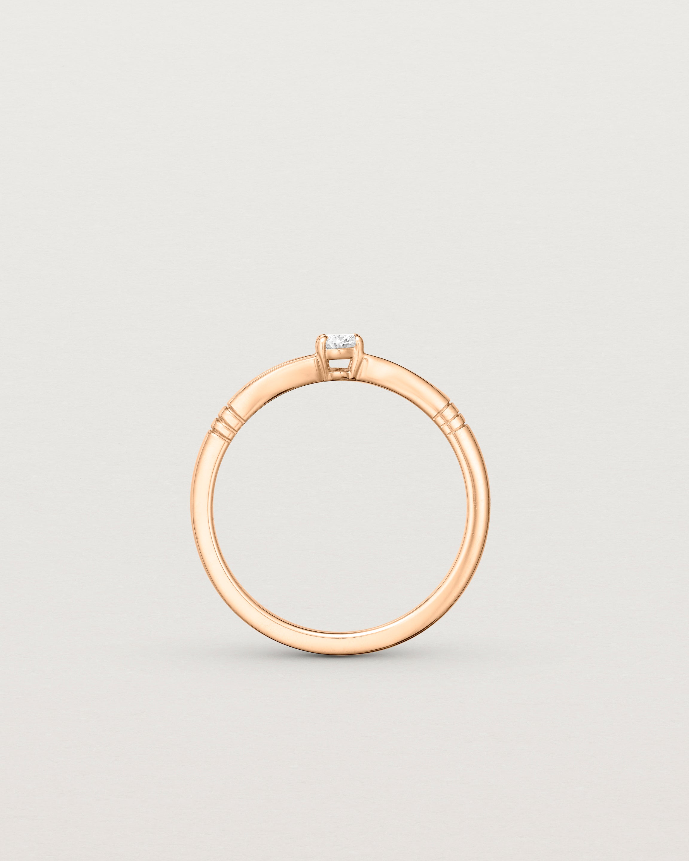 Standing deep etched image of a rose gold engagement ring with an oval diamond